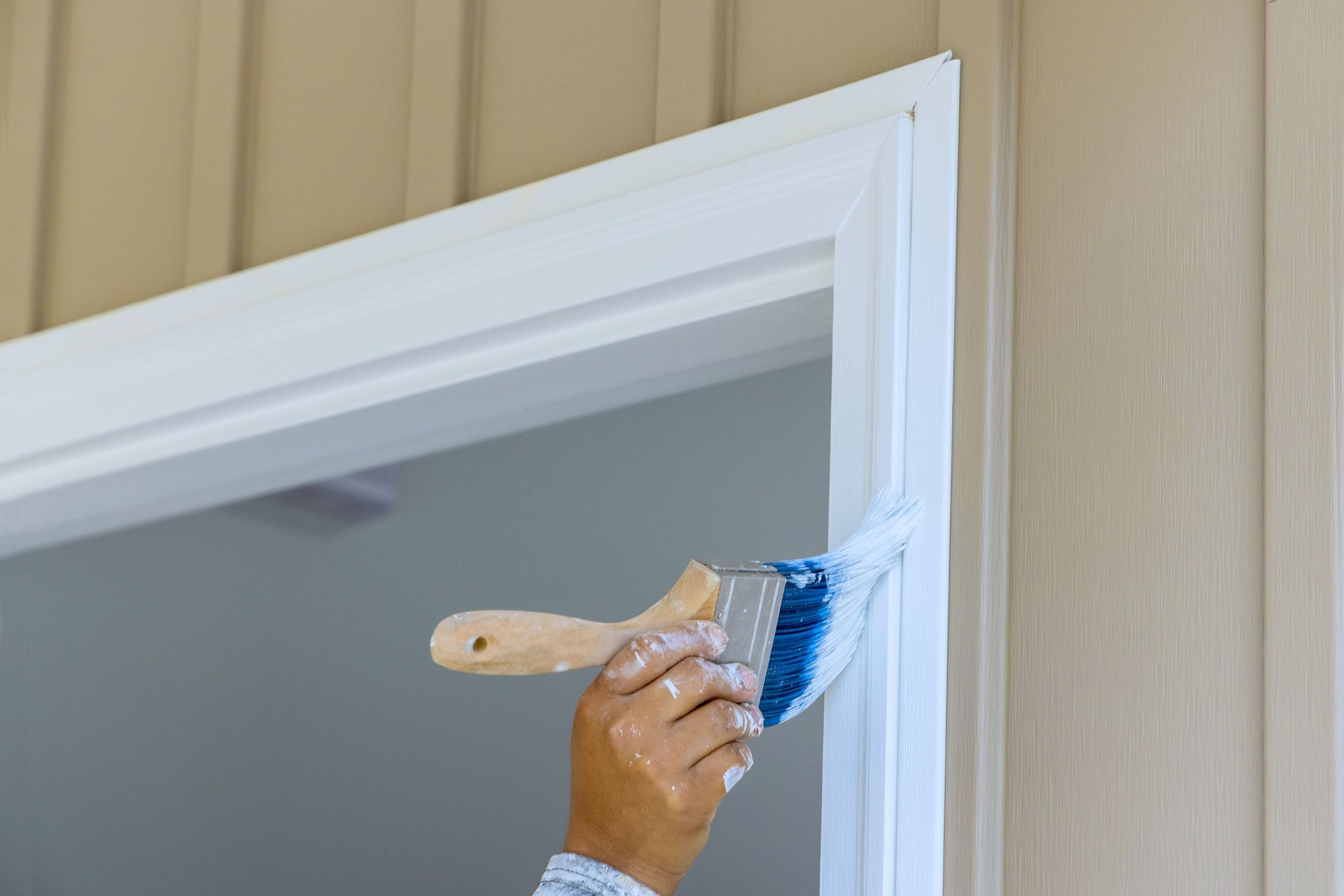 Painter are used paintbrush by to a paint wooden moldings on door trims